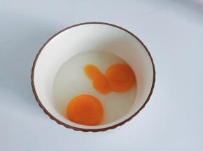 碗里打入两个鸡蛋。