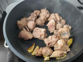 接着倒入准备好的排骨，淋上2勺料酒，翻炒均匀。