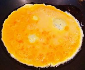锅中倒入底油加热再倒入打散的蛋液中火炒制