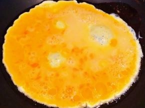 锅中倒入底油加热再倒入打散的蛋液中火炒制
