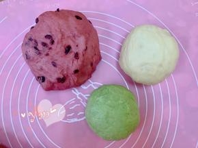 把大面团放回面包机桶，加入2g红曲粉揉匀，再加入一把蔓越莓干，再揉两分钟即可；再取一小块面团加入2g抹茶粉揉匀。