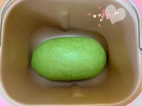 面包机桶的搅拌刀取出，把卷好的面团放入面包机桶内。