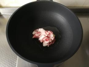 干净不粘锅中，用厨房纸巾擦干水。倒入玉米油，开大火，将玉米油烧热，下姜片爆香。放入五花肉片开始翻炒。
