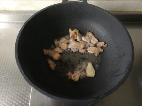 煸炒出香味，然后将肉片煸炒到金黄微焦，让五花肉中的油都煸炒出来。盛出备用。