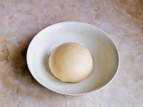 取出面团揉圆，放入器具中。