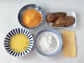 鸡肉腌好后，准备好淀粉、鸡蛋液和面包糠，芝士片对半切好。