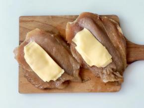 把芝士片夹在鸡胸肉中间，注意留出鸡肉边缘，我在每块鸡排中加了1.5片芝士片，这样爆浆会比较多，可以根据自己的喜好调整芝士的量。