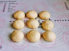 发酵好的面团，用手摁一下，不回缩，不塌陷即为发酵完成，取出面团，揉圆排气，再分成9等份，盖上保鲜膜醒10分钟。