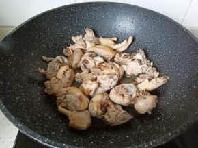 翻炒到鸡块表面微黄，炒出鸡肉当中的油脂，放适量姜蒜翻炒。