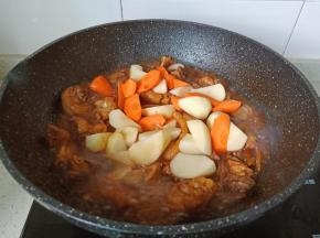 加入土豆与胡萝卜再炖煮10分钟。