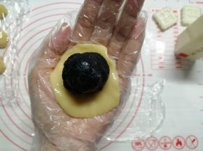 把饼皮放在掌心上，用另一只手掌把饼皮压扁，把馅料放在中间