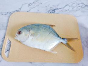 金鲳鱼去腮去内脏洗净，在鱼身上划三道再蒸便于入味。