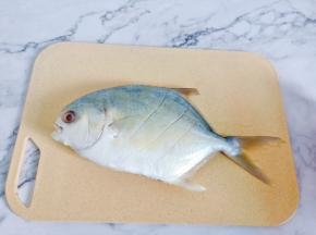 金鲳鱼去腮去内脏洗净，在鱼身上划三道再蒸便于入味。