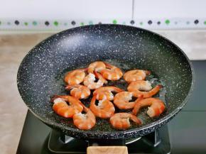 起油锅，先加入虾尾小火煎至变色。