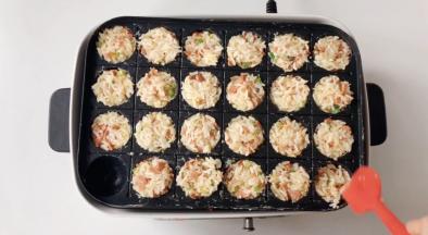 把拌好的米饭填入章鱼烧盘，压实，用中火煎。