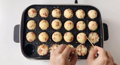 底部煎至定型后，借助竹签把饭团翻个面儿。