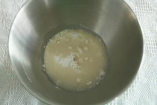 步骤2、将鲜酵母和糖倒入常温水中，搅拌融化。然后打面桶中，倒入高粉，再倒入酵母水。厨师机开1档混合成团，转2档揉面3分钟。