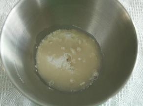 步骤2、将鲜酵母和糖倒入常温水中，搅拌融化。然后打面桶中，倒入高粉，再倒入酵母水。厨师机开1档混合成团，转2档揉面3分钟。