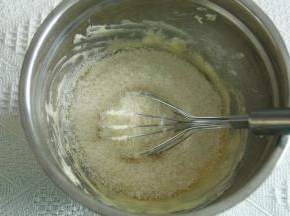 步骤5、软化到能用刮刀轻易抹开的黄油，用蛋抽打顺滑，加糖粉（如有结块需过筛），搅打至微微变白。分次加入常温全蛋液，搅打顺滑。再倒入所有椰蓉和奶粉。