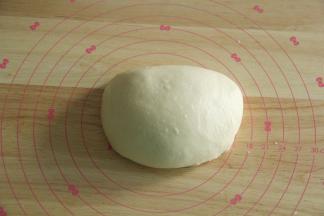 步骤10、直到面团能扯出结实薄膜，破洞边缘基本光滑。将面团取出。双手握住面团，向外折叠收圆，盖保鲜膜，常温松弛30分钟左右。看体积略微膨胀，手指碰触有空气感即可。