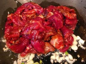 锅中倒入底油放入葱姜蒜爆香再放入牛肉片大火快速炒至变色