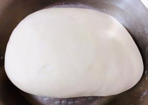 面粉倒入适量清水活成面团醒制二十分钟再轻柔排气面团就更加光滑