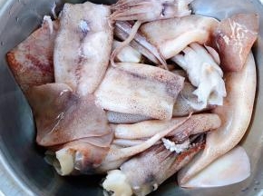 新鲜的鱿鱼先从头部挤出鱿鱼嘴再取出内脏和硬核洗净备用