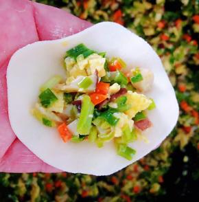 取适量一块面团搓揉好分成小剂子擀成饺子皮取一个饺子皮适量的馅料放在中间对折包好饺子