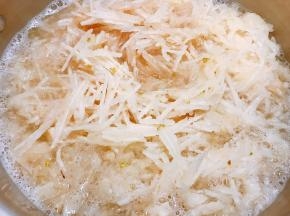 把擦成丝的雪梨连同汁水一起倒入大锅里