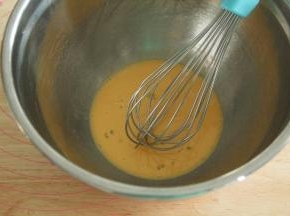 蛋黄25克放入干净盆中，倒入朗姆酒，用蛋抽搅打均匀。