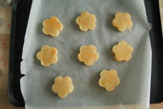 冷冻完成，取出，用模具切出形状。排入垫了油纸的烤盘中。均匀刷上一层蛋液（蛋黄一个加牛奶2-3克混匀即可）。