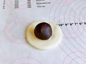 取一块麻薯，压扁放上豆沙蛋黄馅包起来捏紧。