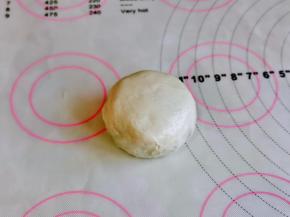 用手抓饼包上麻薯豆沙蛋黄酥，收口捏紧朝下揉圆，这样就做好啦。