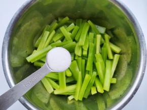 莴笋去皮切成大一点的条，放入大盆中，加一小勺食盐，拌匀腌制30分钟。