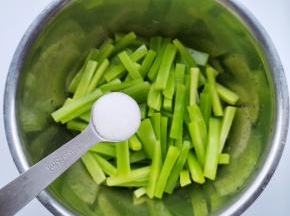 莴笋去皮切成大一点的条，放入大盆中，加一小勺食盐，拌匀腌制30分钟。