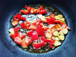 油热爆香蒜末，放红椒翻炒，