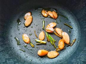 另起锅热油，放葱段炒香，加入火腿炒硬，