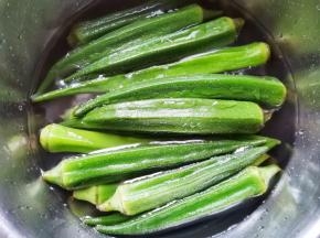 秋葵盐水浸泡5分钟清洗干净。锅中烧开水加一丢丢油和盐，放入秋葵焯水一分钟捞出过凉。