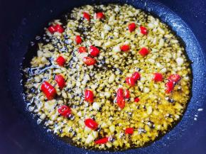 锅内热油，放大蒜小米椒爆香，