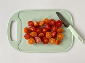 把洗净的樱桃番茄对半切好。