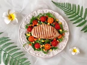 盘子中间放入烤好的鸡胸肉，磨上黑胡椒碎。