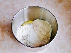 再加入高筋面粉，面粉顶部挖个洞，放入酵母粉，再用面粉盖起来，最后加入发酵好的波兰种，启动厨师机2档揉面。