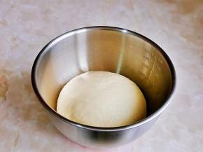 取出面团揉圆，放入器具中。