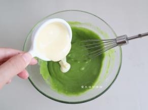 用手抽把蛋黄和抹茶面糊拌匀后，倒入炼乳搅拌均匀。