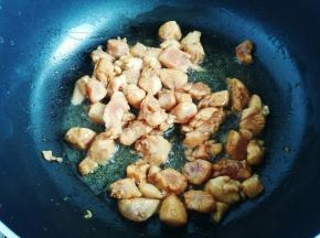 起锅热油，油热下入鸡肉丁翻炒。