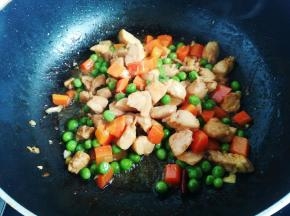 八分熟时下入豌豆胡萝卜丁继续翻炒，出锅前适量盐调味。