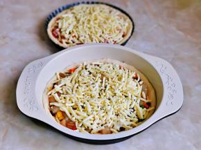 再分别撒上一层马苏里拉芝士，最后撒上罗勒碎，两个披萨就准备好啦！