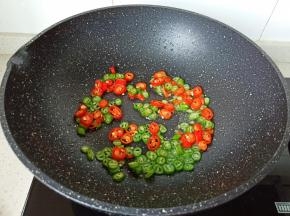 锅里重新放油，放青红椒丁翻炒一下。