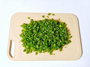 青辣椒清洗后控干水分，放在案板上剁成小粒。