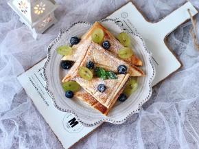 三明治切好摆盘，蓝莓和青提洗净，把青提切开，摆在三明治上装饰一下，再放上薄荷叶，最后撒上糖粉，好看又好吃！